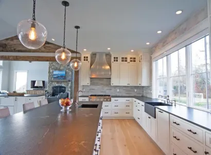 A kitchen with white cabinets and black counter tops