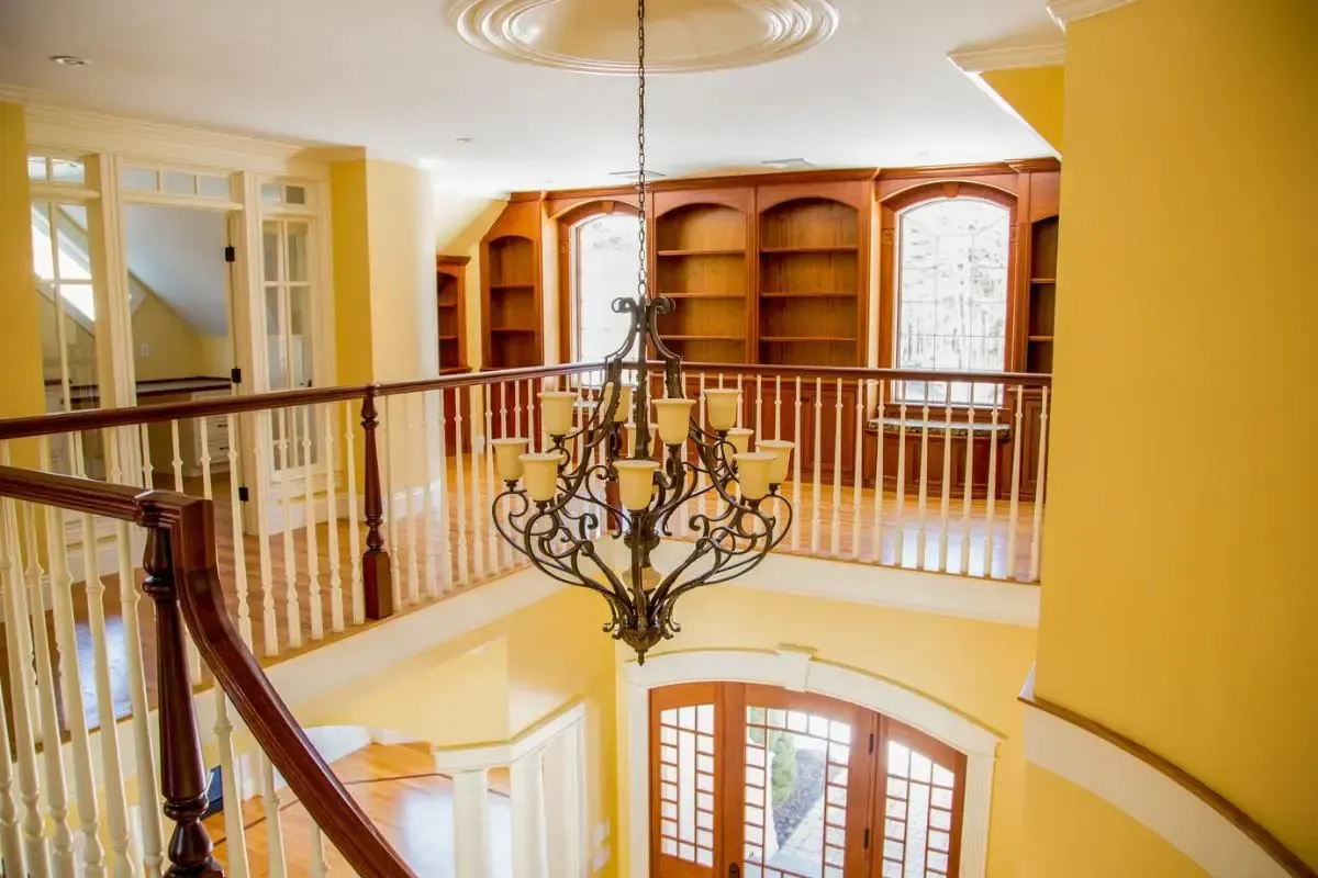 There is a chandelier hanging from the ceiling in the middle of the room.