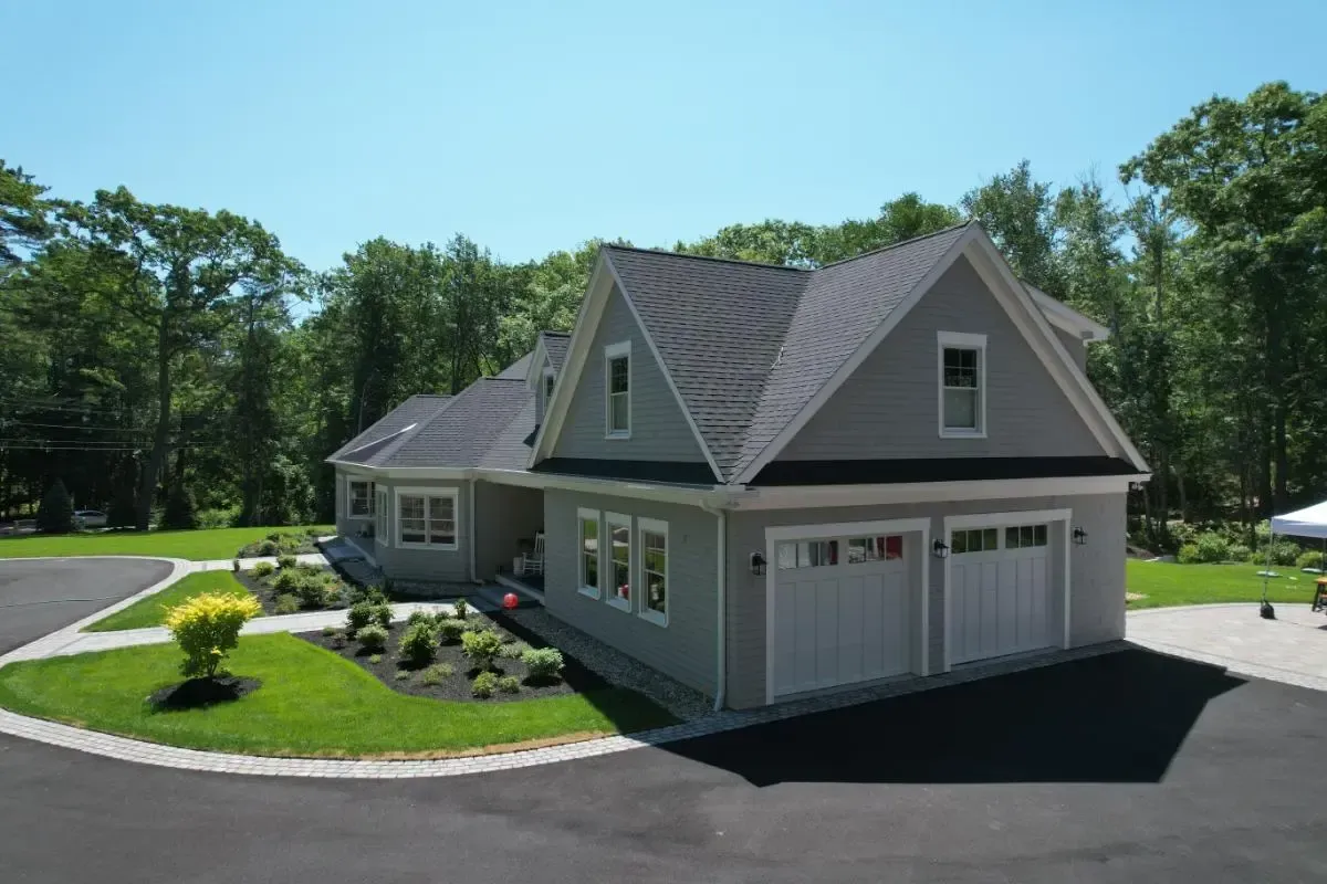 An aerial view of a house with a garage and a driveway