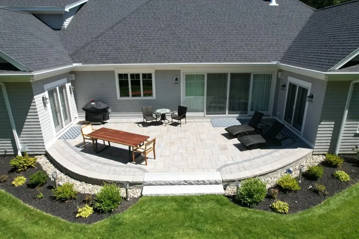 An aerial view of a patio with a table and chairs in front of a house.