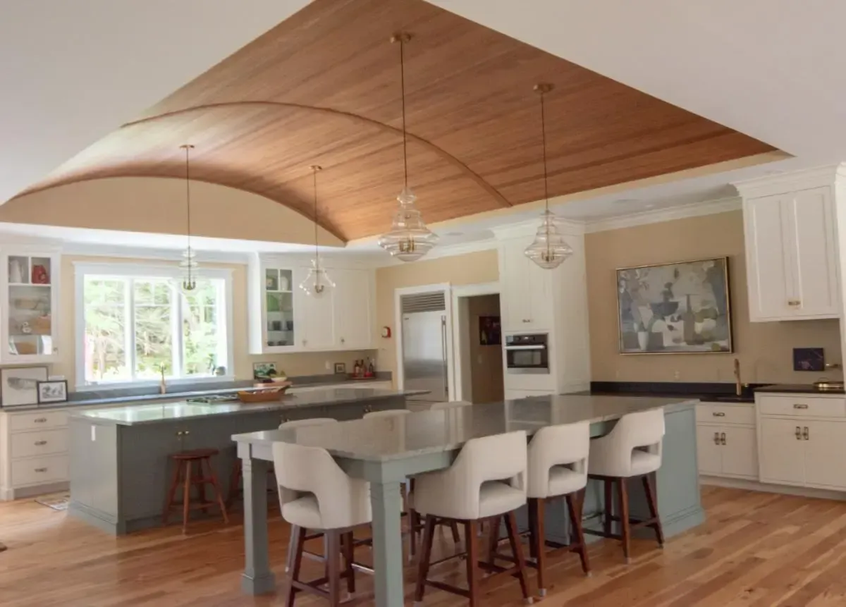 A kitchen with a curved ceiling and a large island