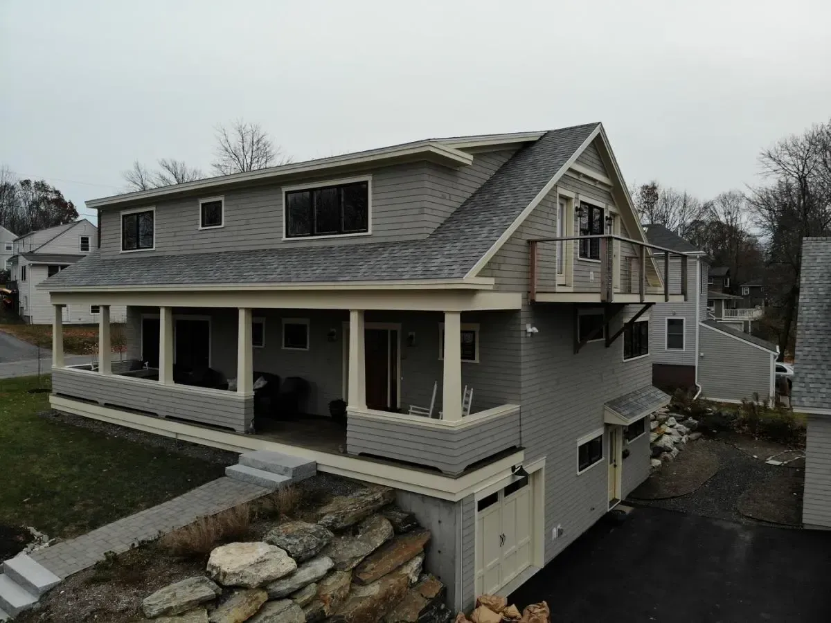An aerial view of a house with a large porch and a garage.