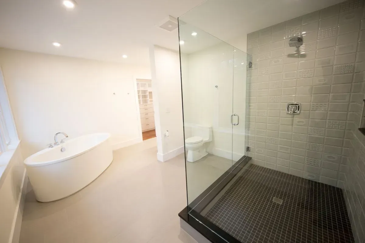 A bathroom with a bathtub , toilet , shower and walk in shower.