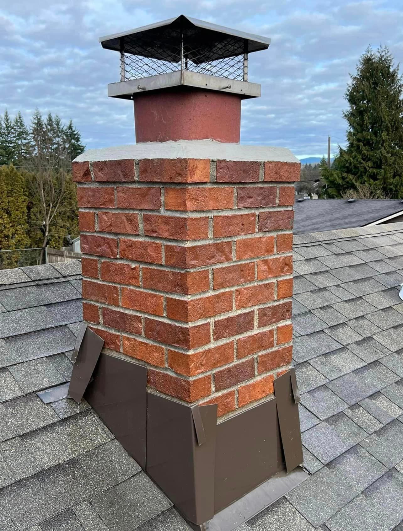 A brick chimney is sitting on top of a roof.