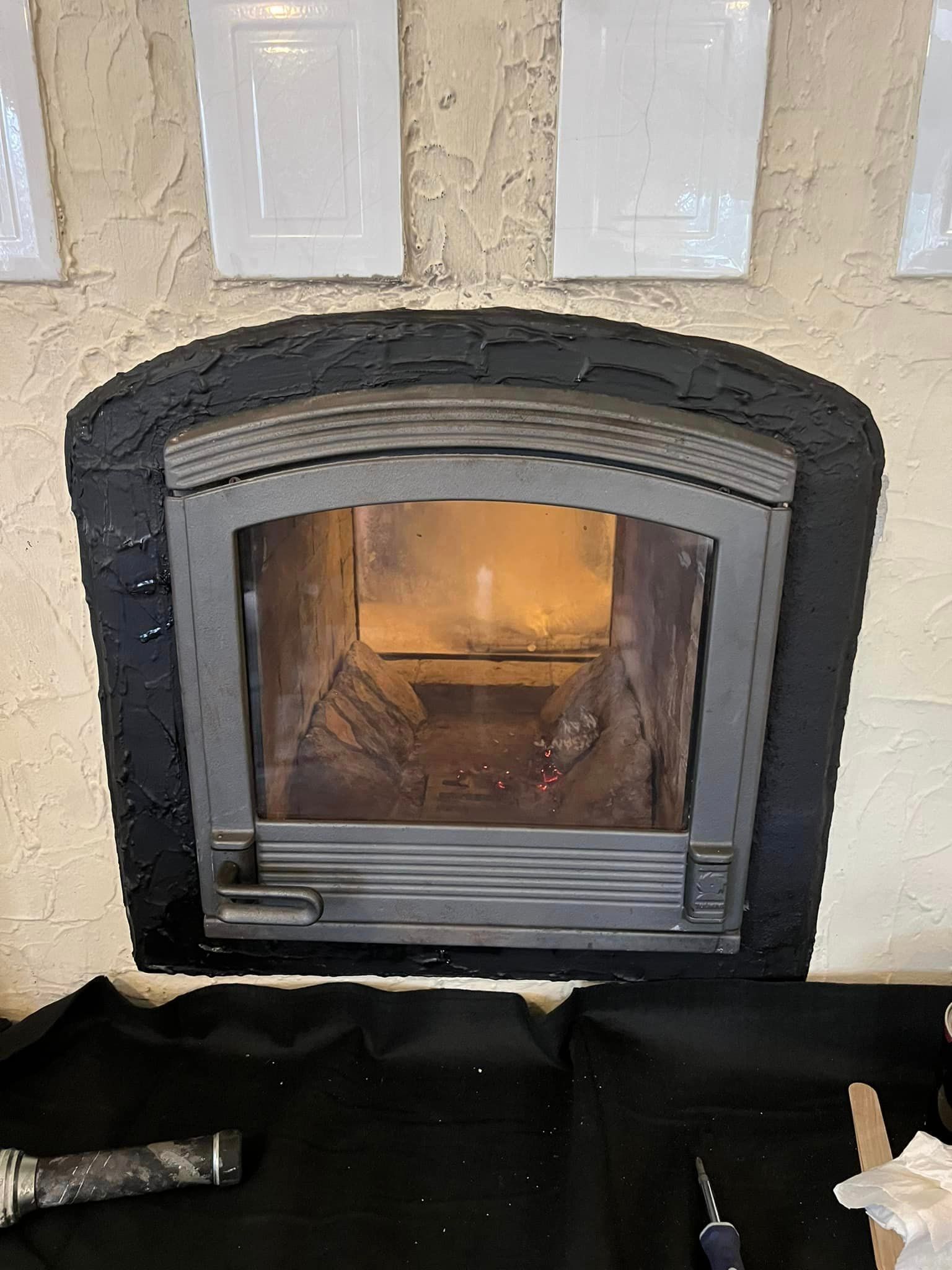 A fireplace with a glass door is sitting on top of a black table.