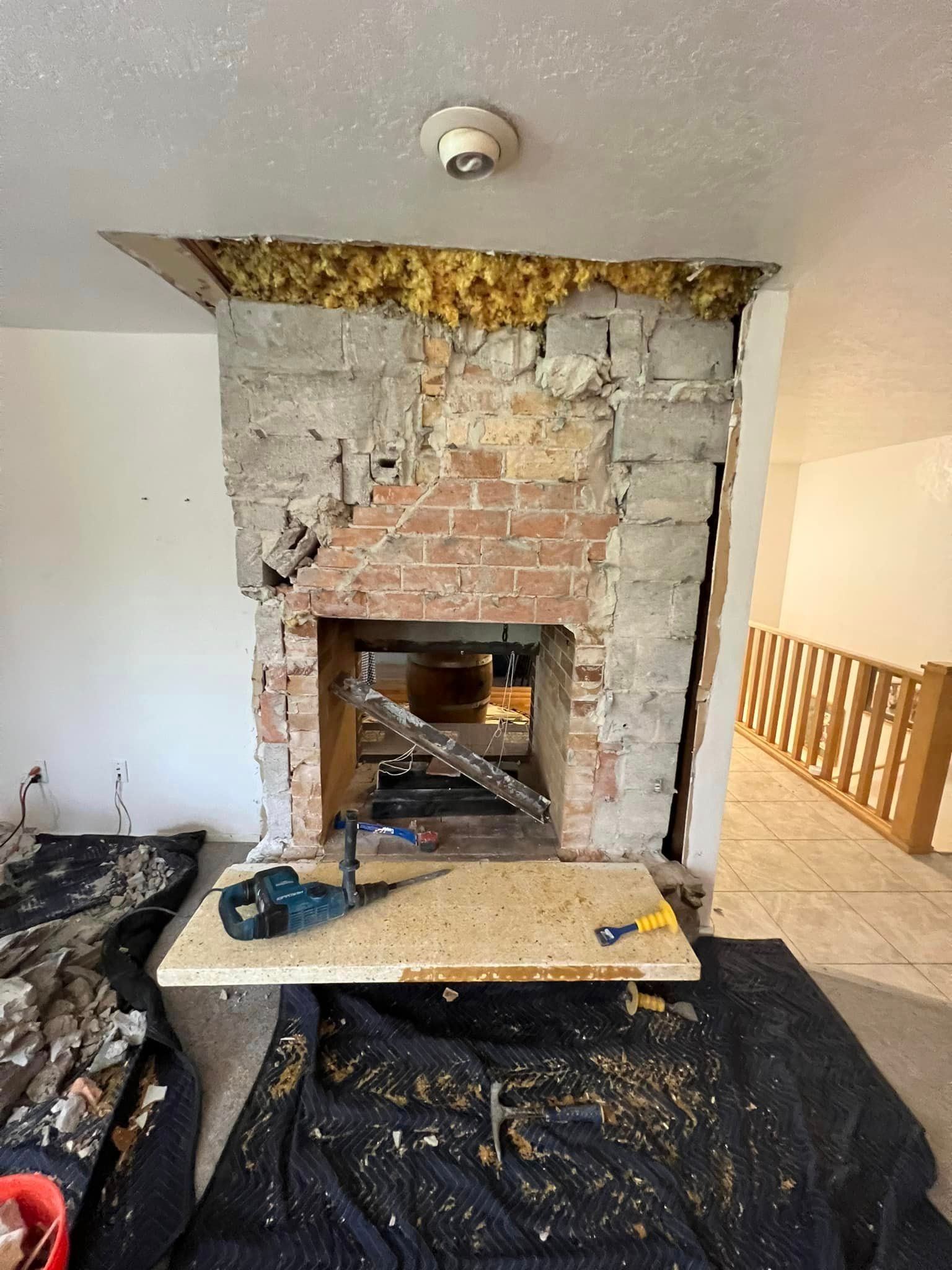 A brick fireplace is being remodeled in a living room.