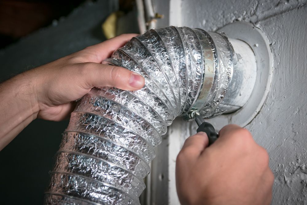 A person is fixing a duct with a pair of pliers.