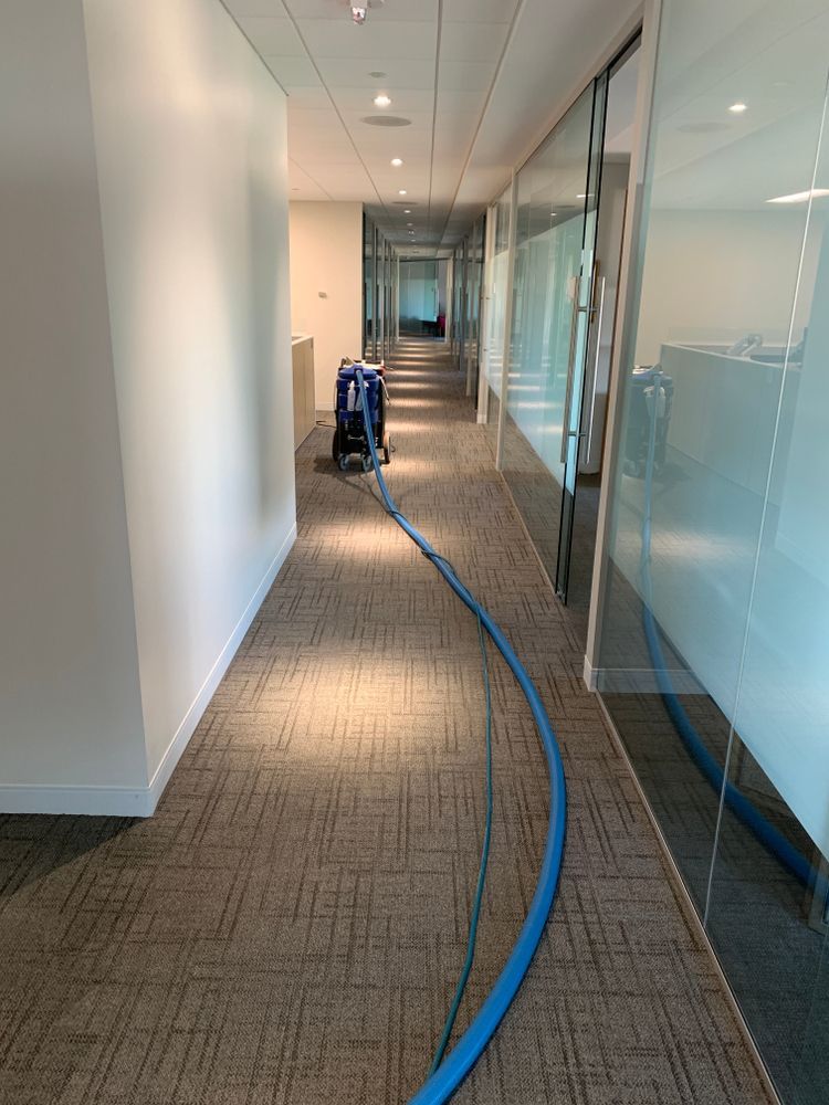 A long hallway with a vacuum cleaner in the middle of it.