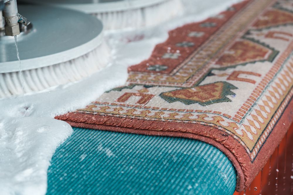 A rug is being cleaned by a machine.