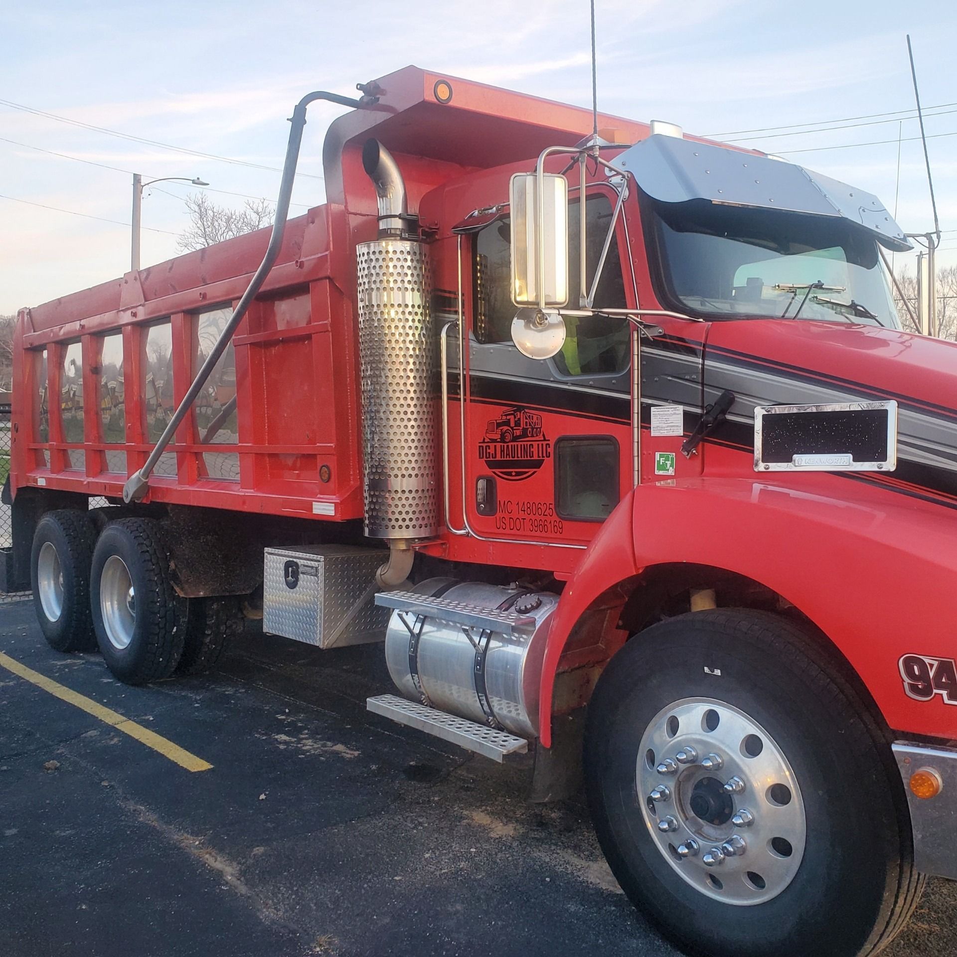 Red dump truck parked in a parking lot.