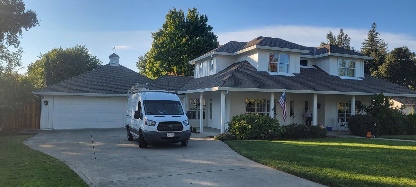 Suburban house with a white van parked in the driveway at sunset