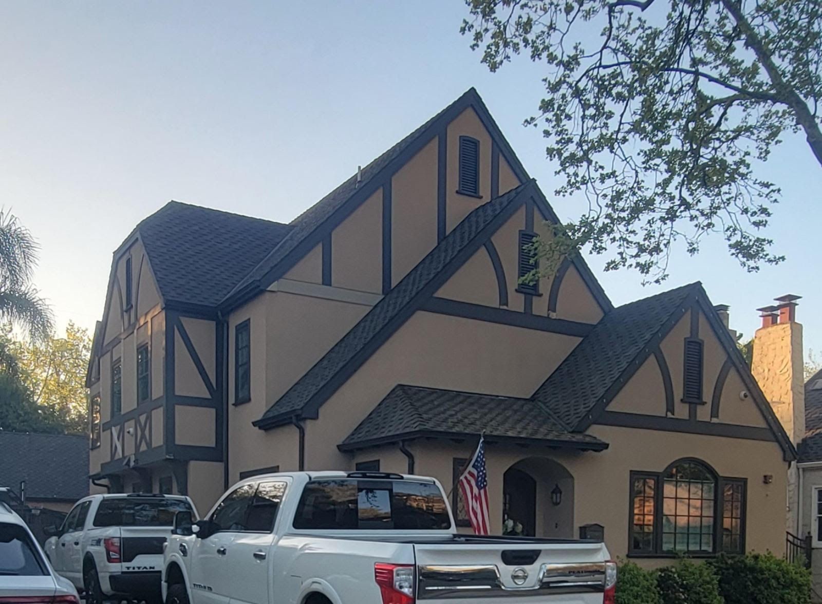 Tudor-style house with a white pickup truck parked in front at dusk