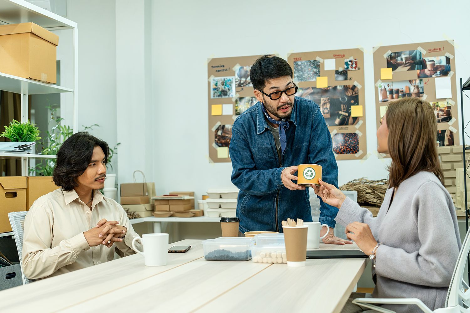 Team discussing eco-friendly packaging prototype in modern workspace for sustainable product design. Team discussing eco-friendly packaging prototype in modern workspace for sustainable product design.