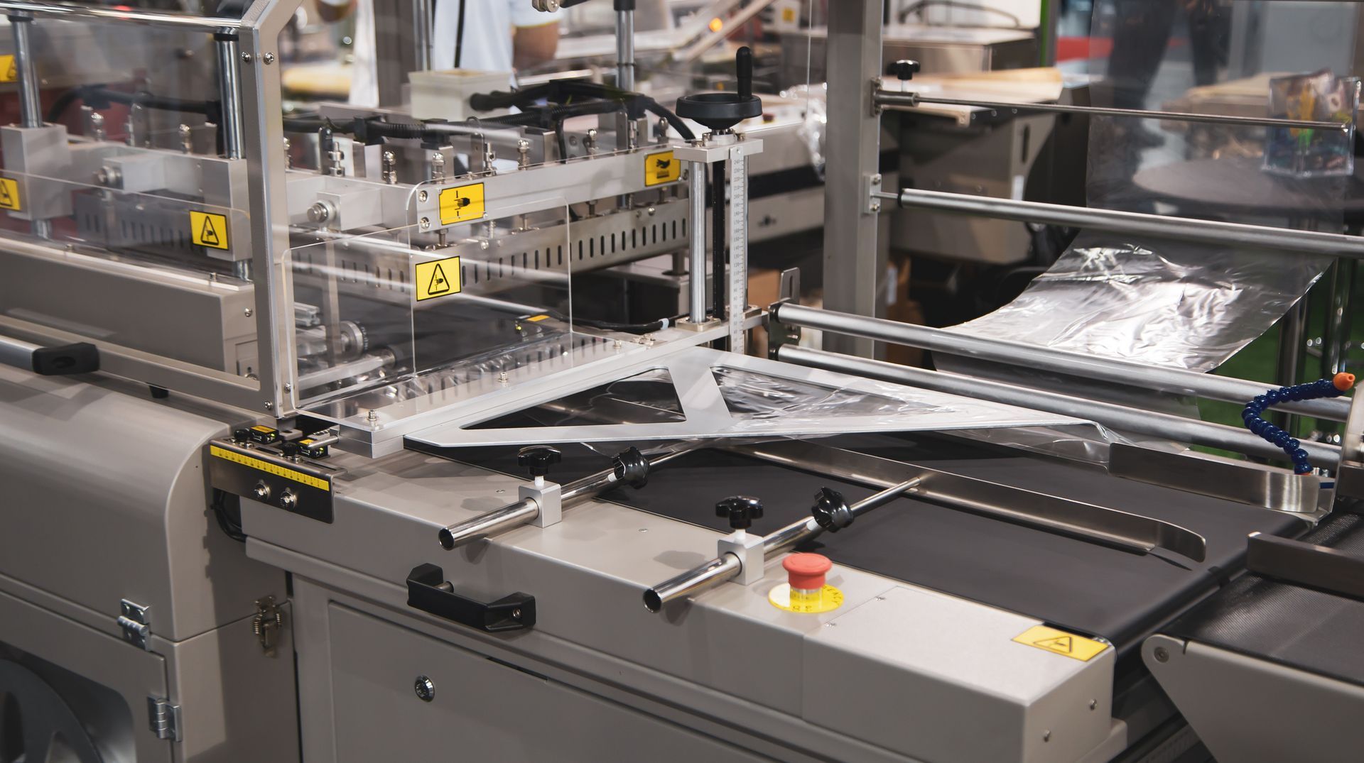 A machine is moving a piece of plastic on a conveyor belt.