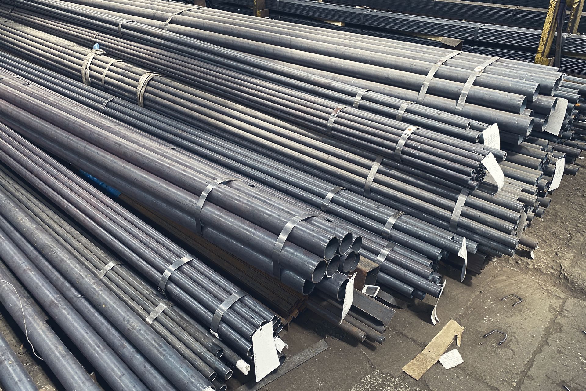 A bunch of metal pipes are stacked on top of each other on the ground.