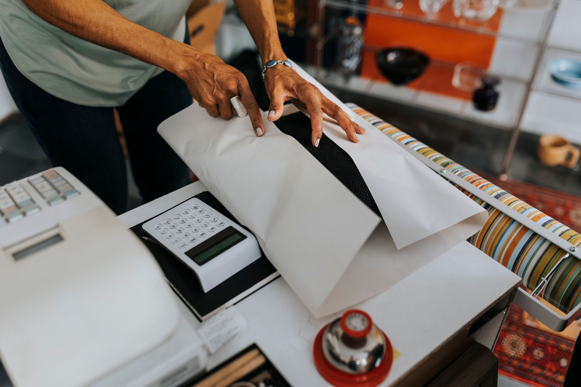 A person is cutting a piece of paper on a table.