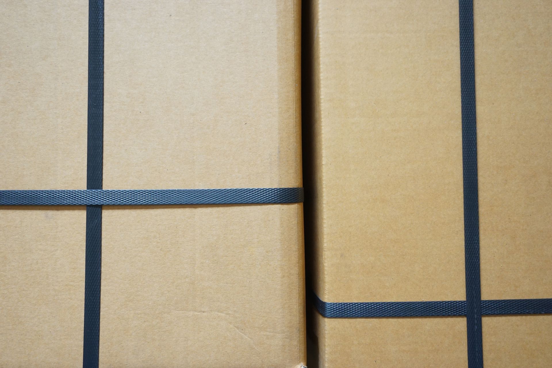 Two brown boxes wrapped in brown paper and tied with black ribbon.