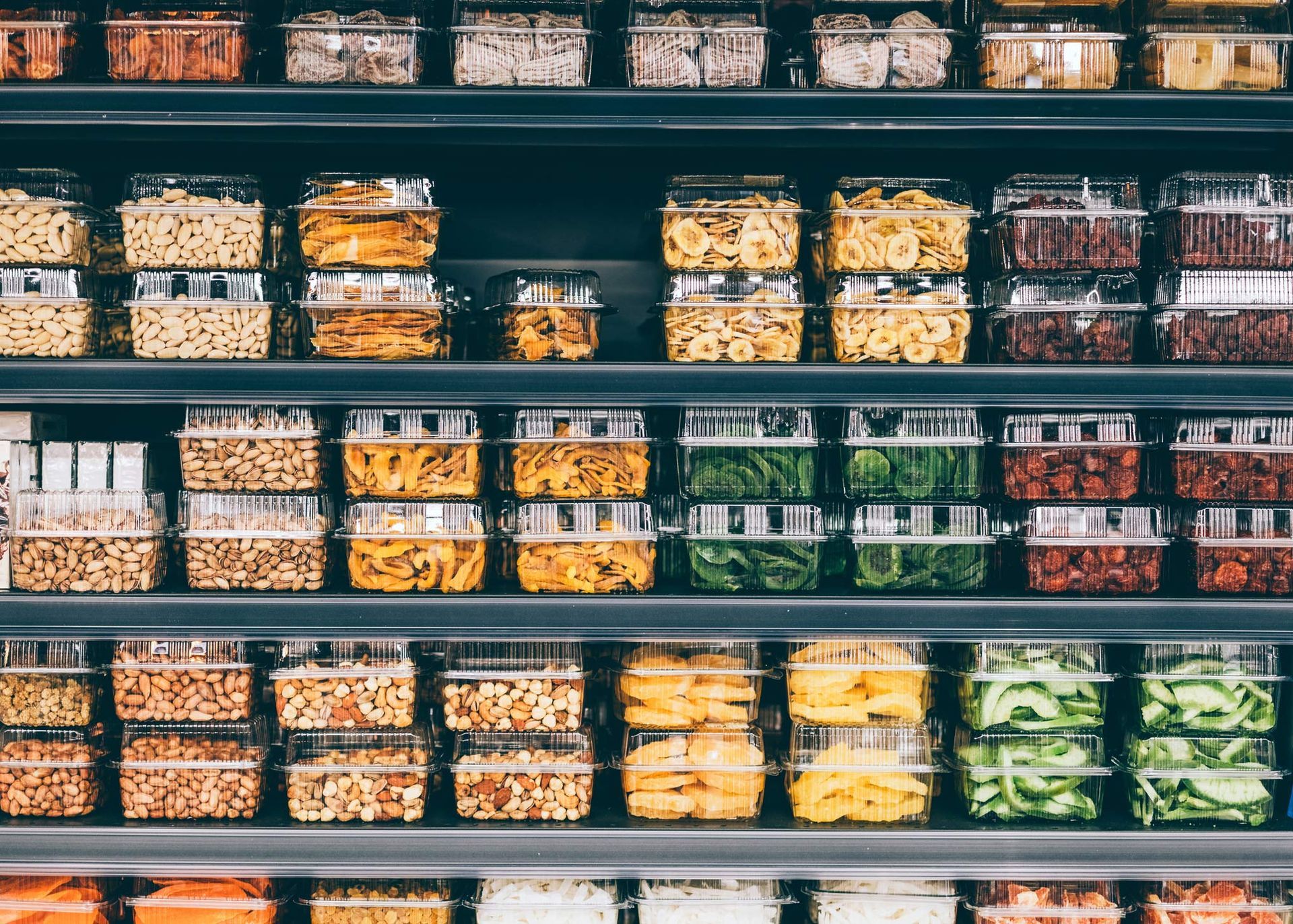 Store shelves with dried fruit, veggies, and nuts in a non-ecological packaging.