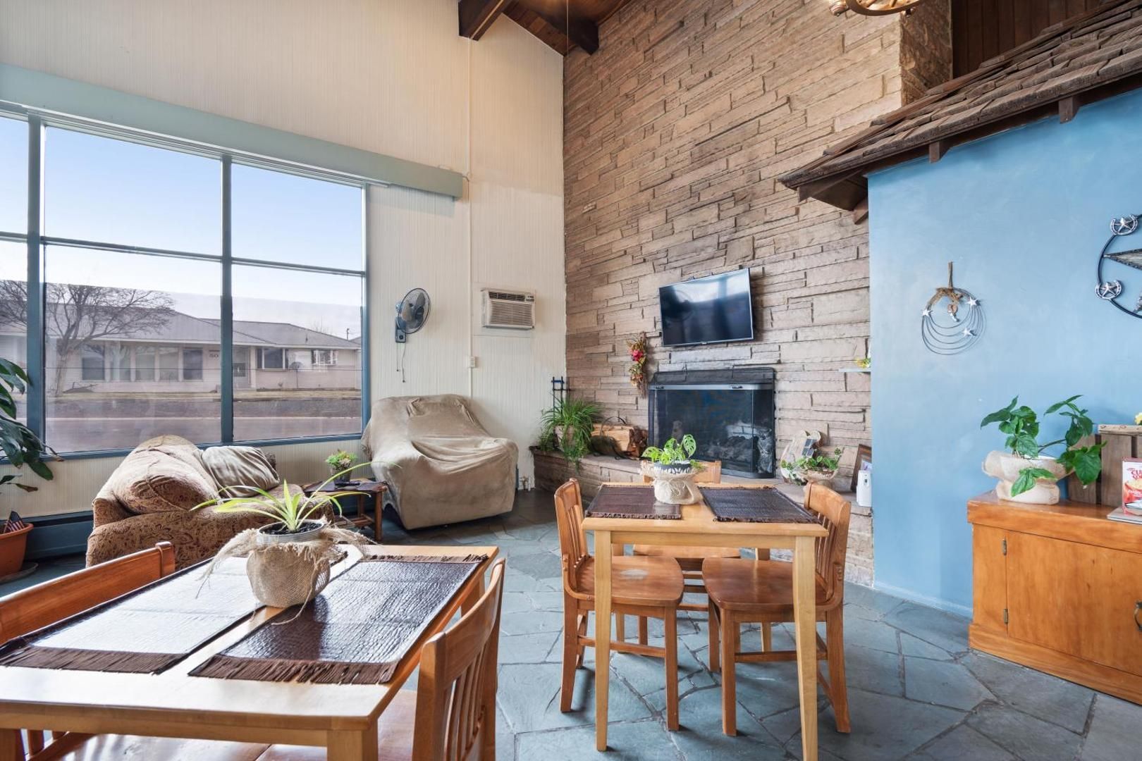 A living room with a table and chairs and a fireplace.