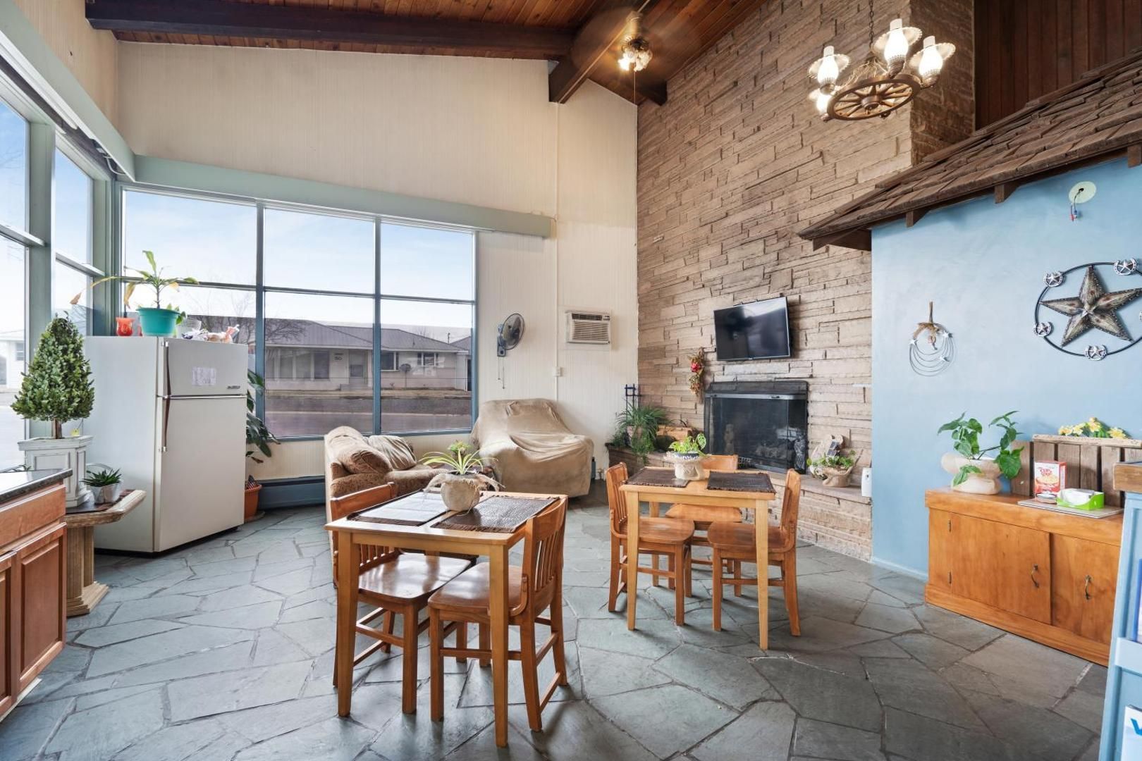 A living room with tables and chairs and a fireplace.