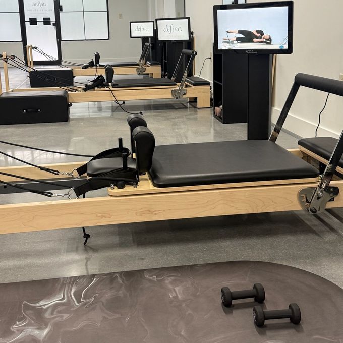 Reformer station at Define Pilates in Buford with a personal screen showing an instructor-led workout