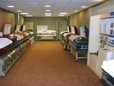 Mattress showroom with rows of beds displayed along both walls under bright ceiling lights