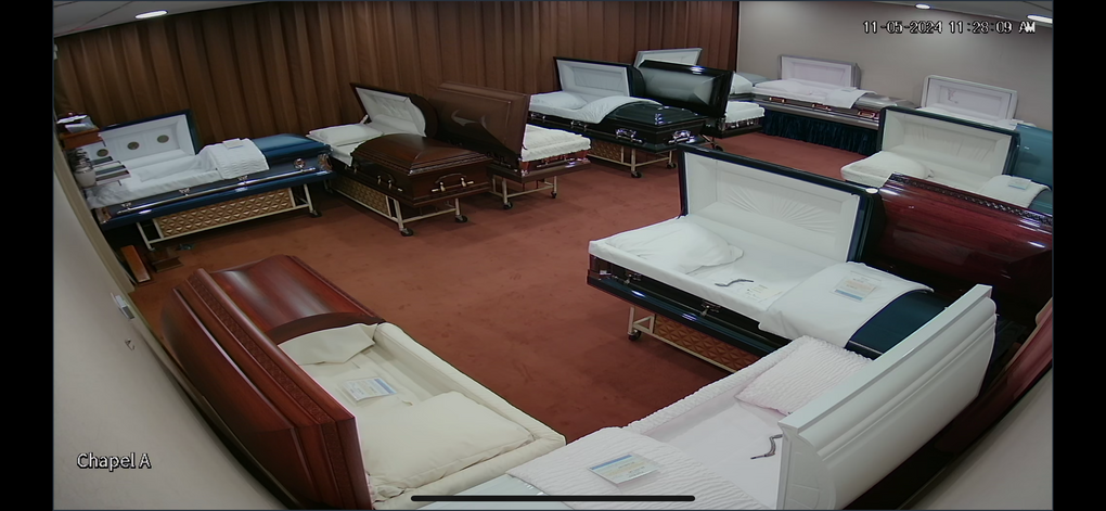 Empty living room with white and brown sofas arranged around a red carpet