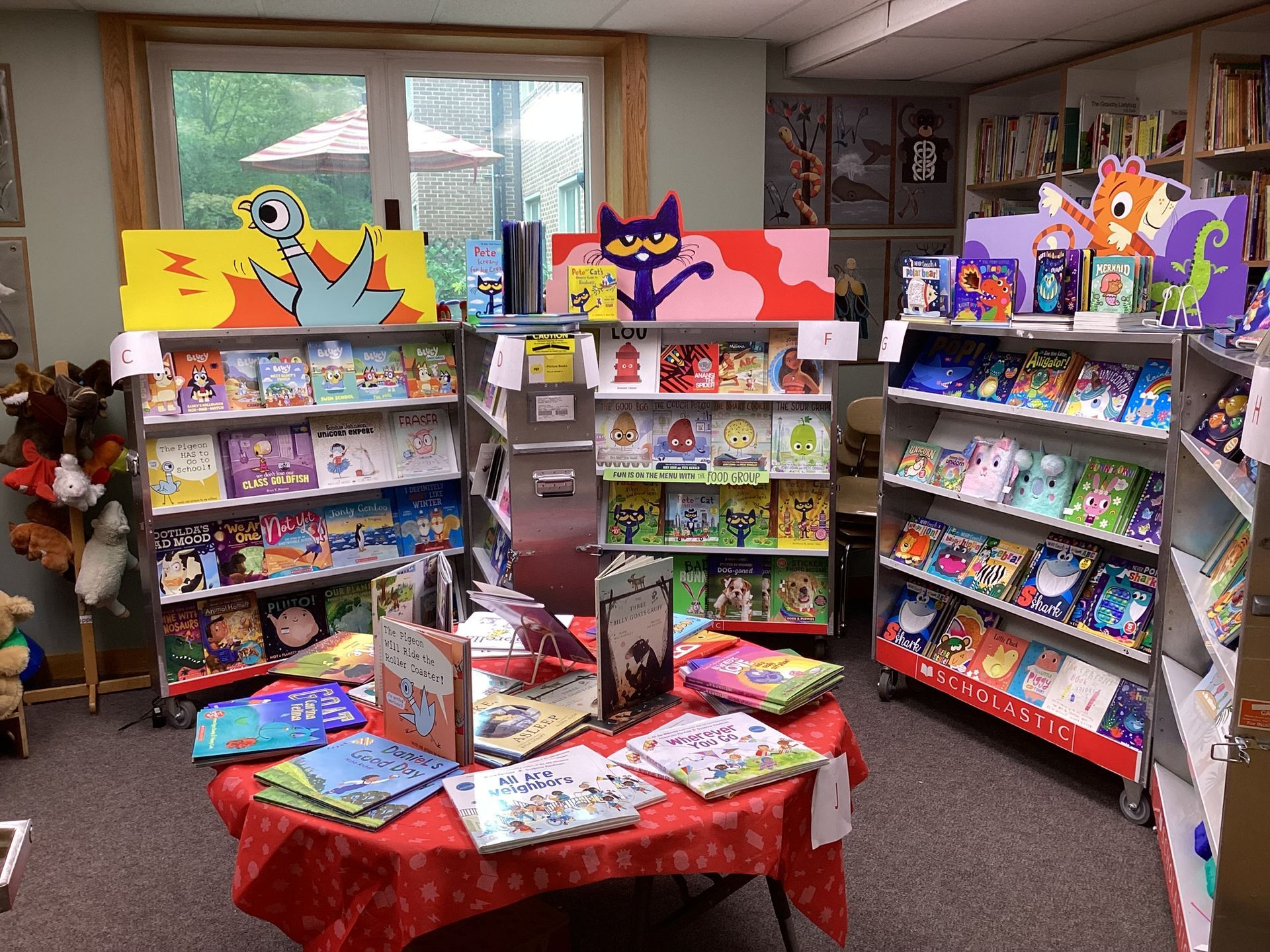 A bookstore display featuring children's books. Colorful book covers and cartoon art decorate shelves and a central table.
