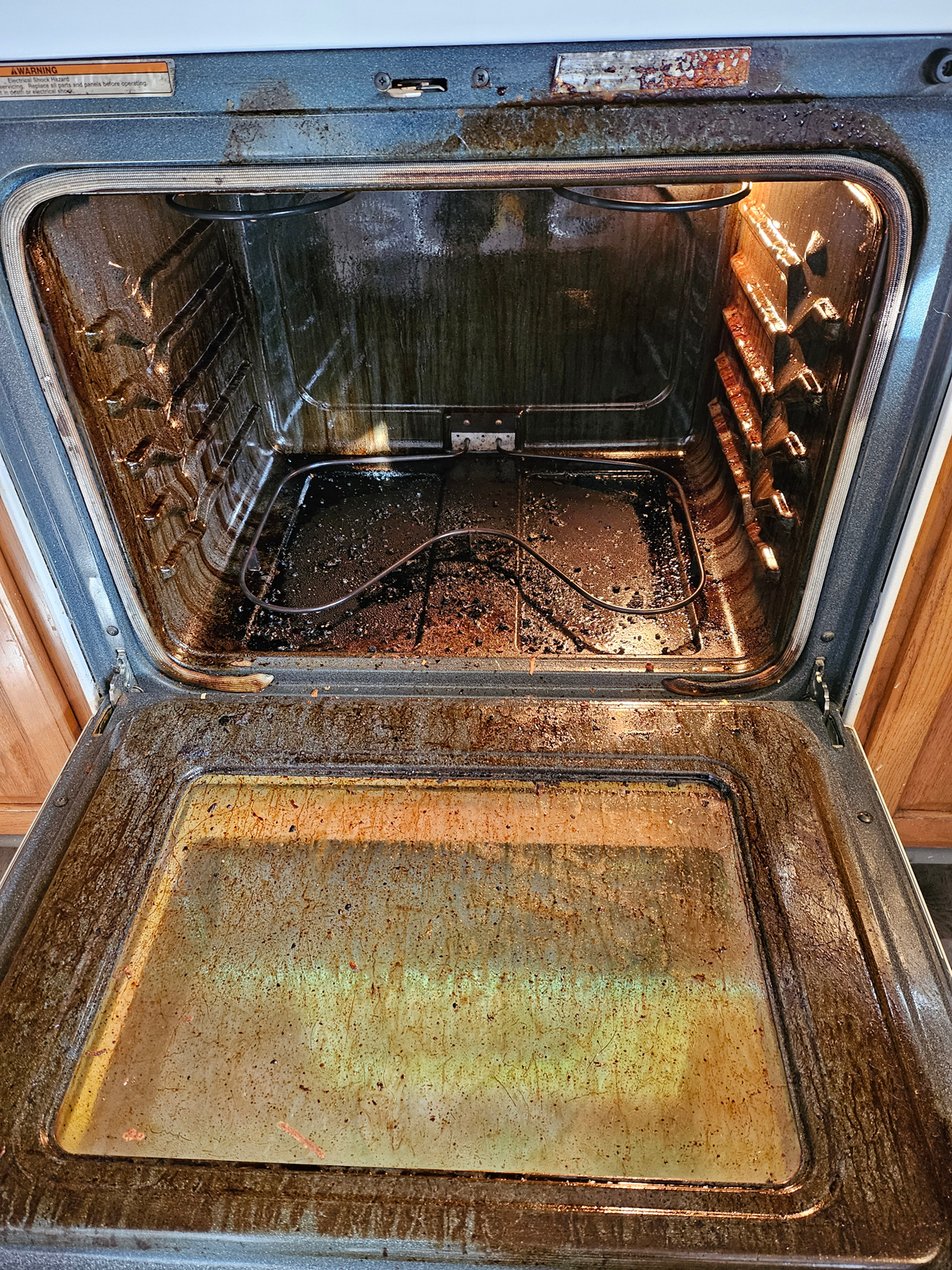The inside of an oven is very dirty and needs to be cleaned.