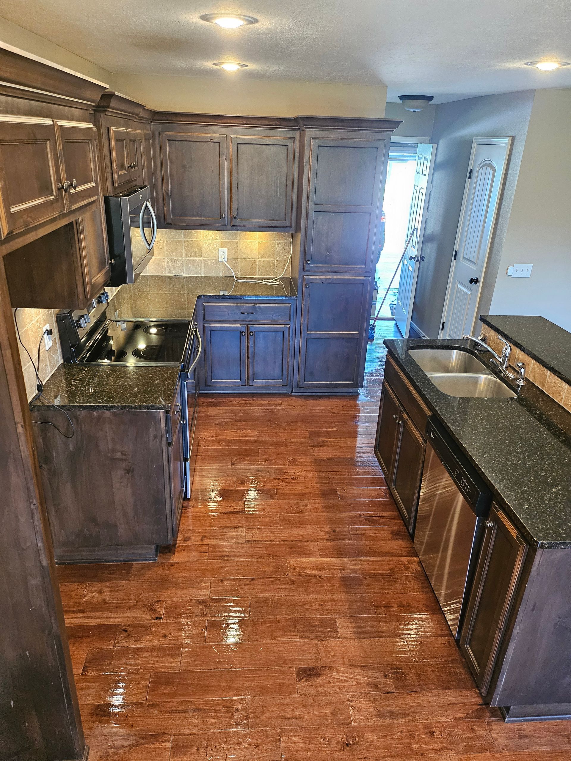 A kitchen with hardwood floors and granite counter tops.