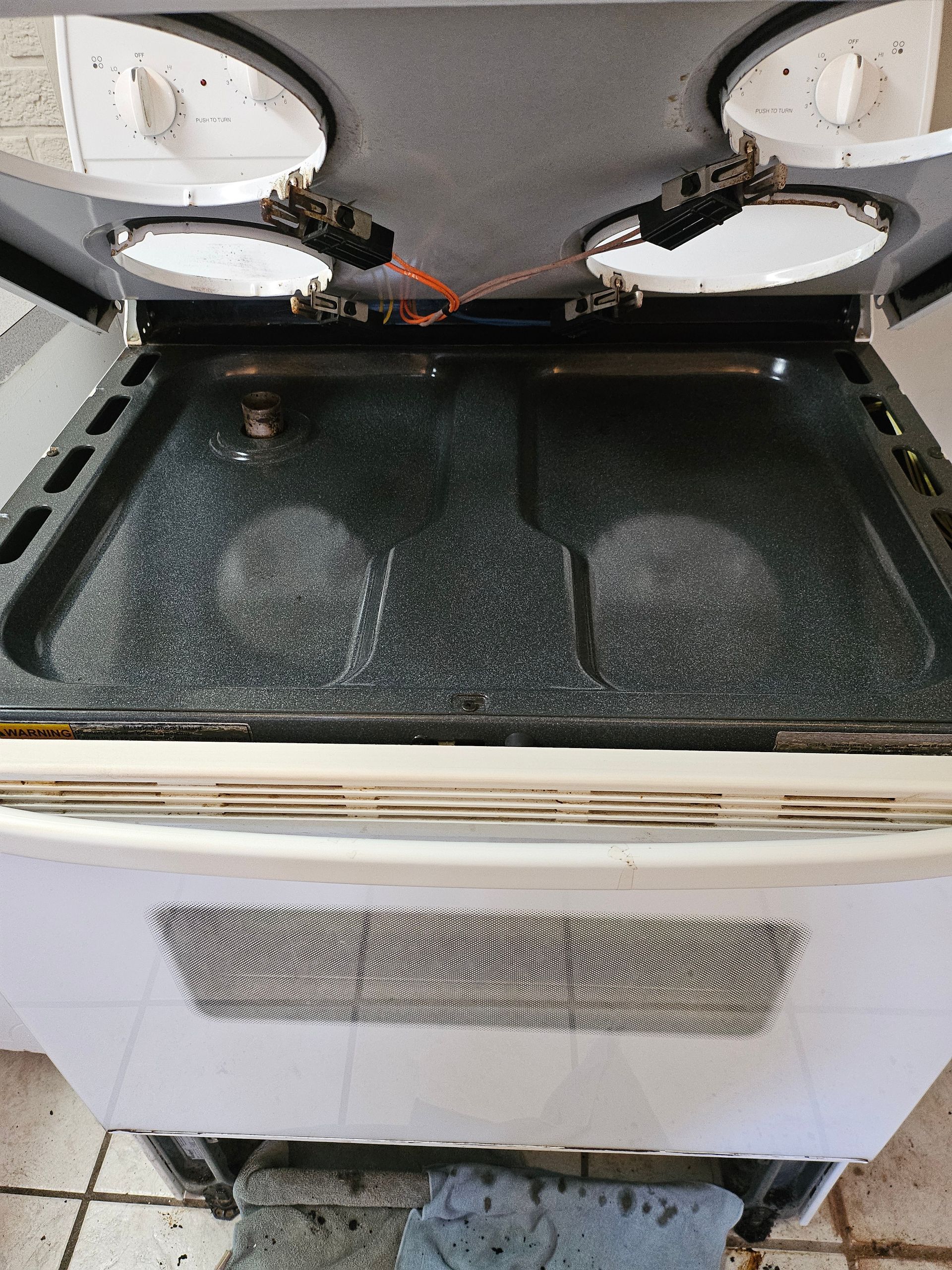 A white stove top oven with the door open