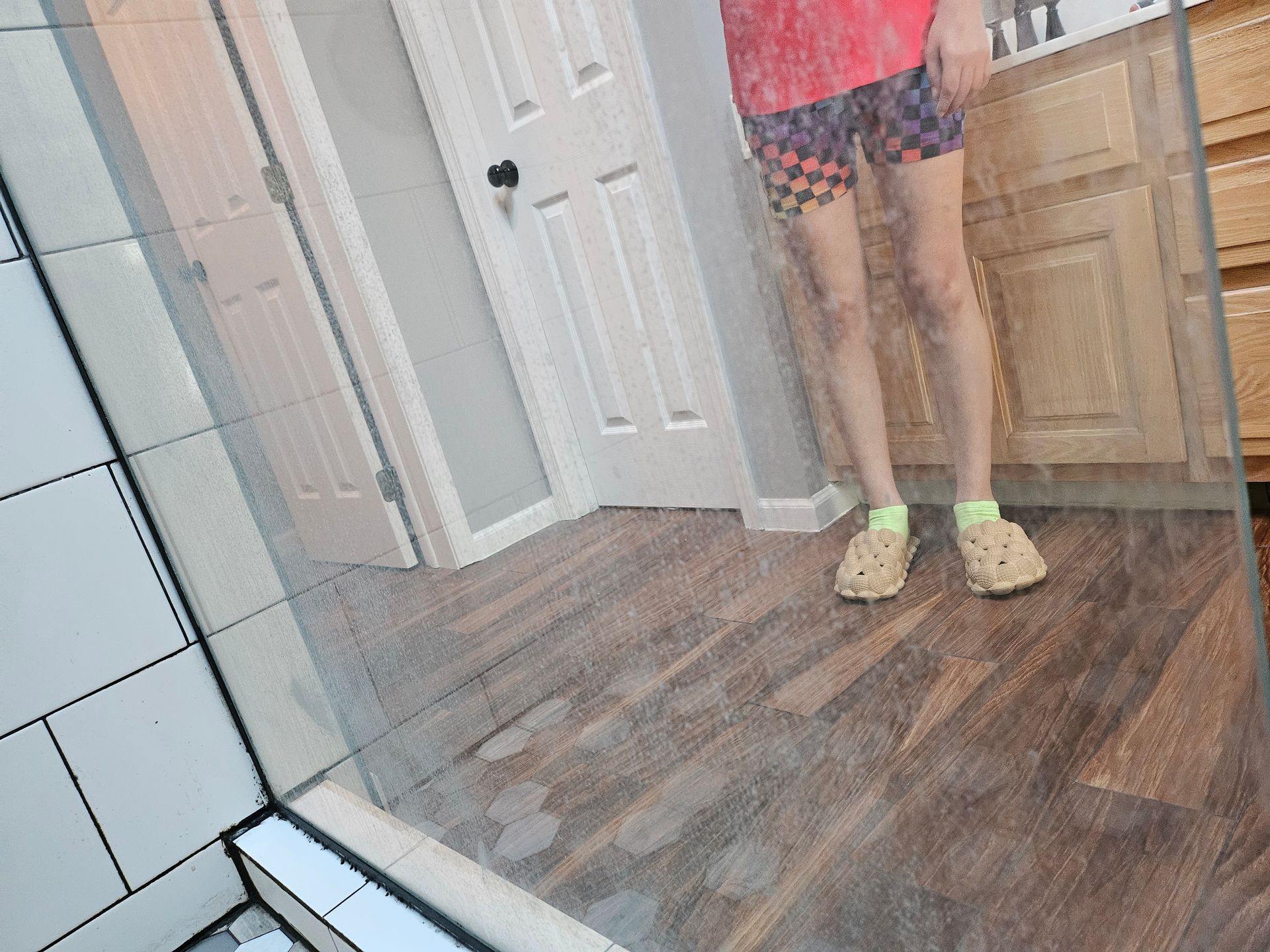A person is standing in front of a mirror in a bathroom.