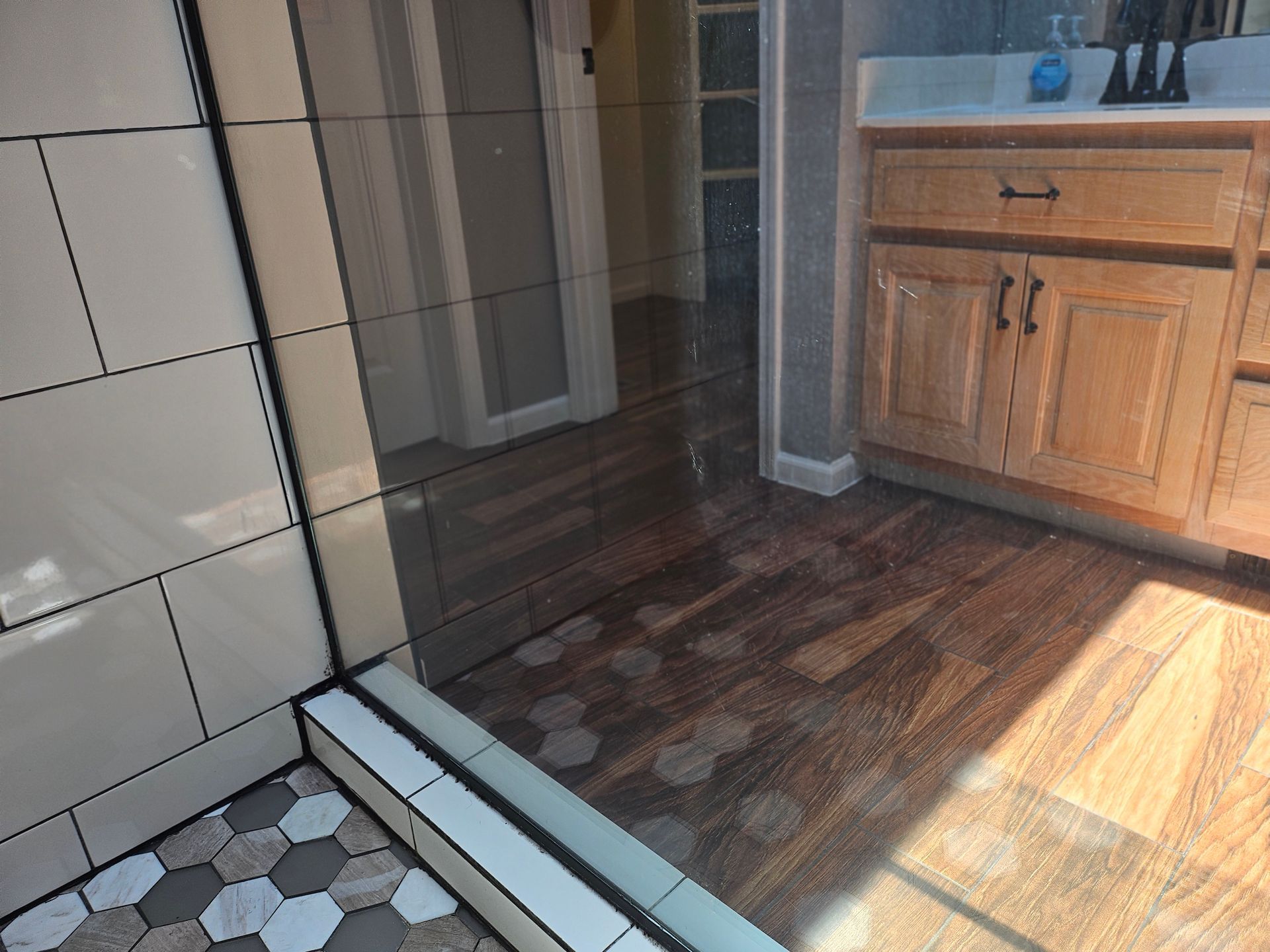 A bathroom with a walk in shower and a sink