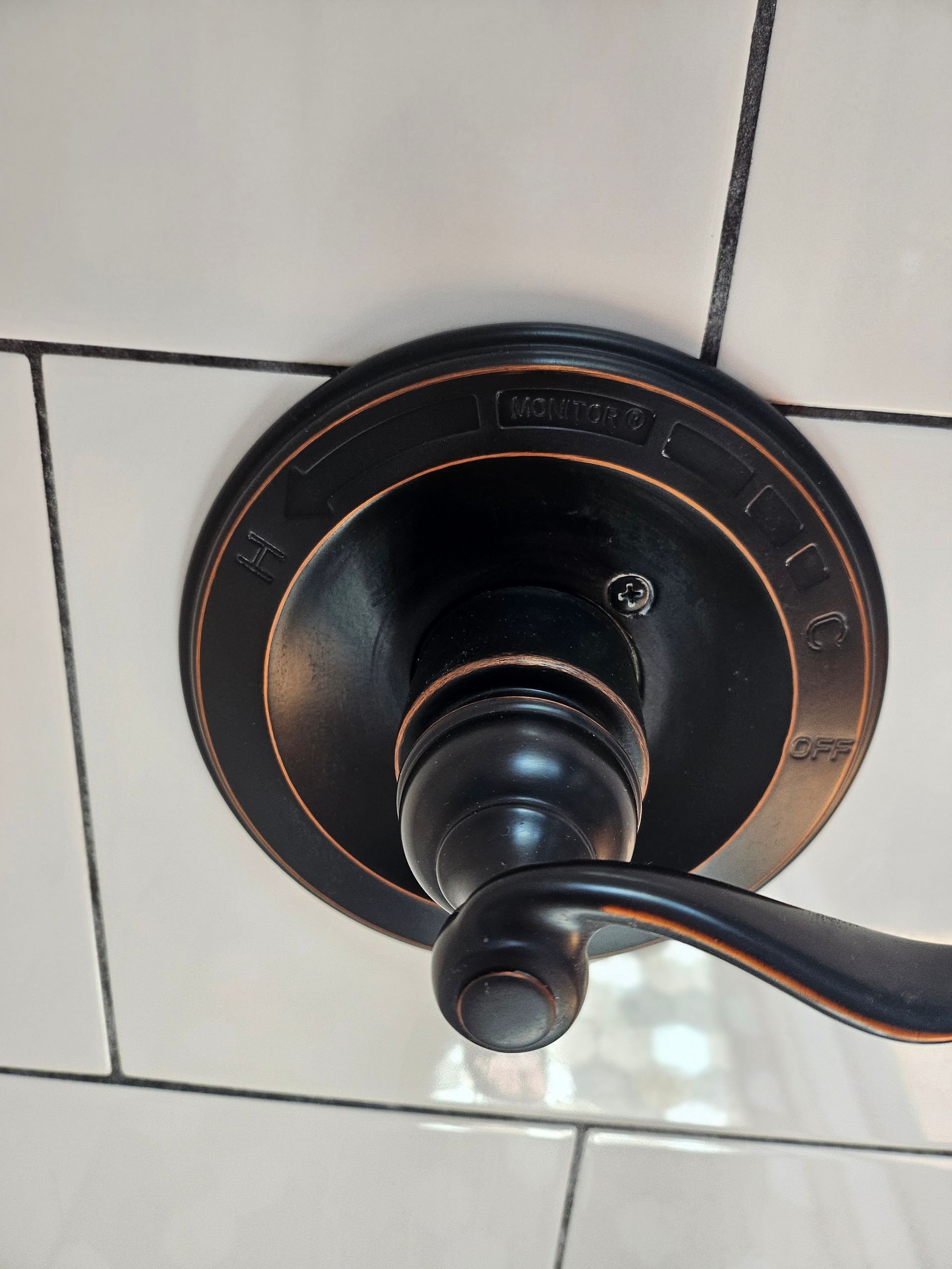 A close up of a door knob on a tiled wall