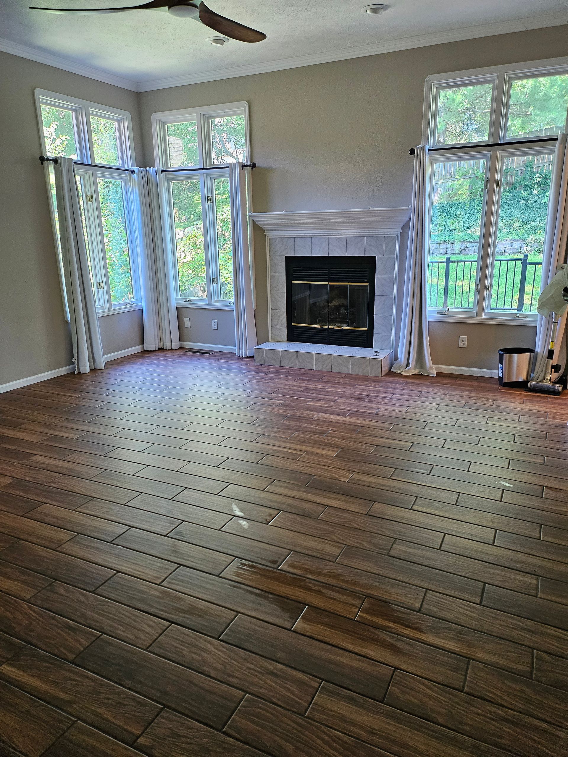 An empty living room with hardwood floors and a fireplace.
