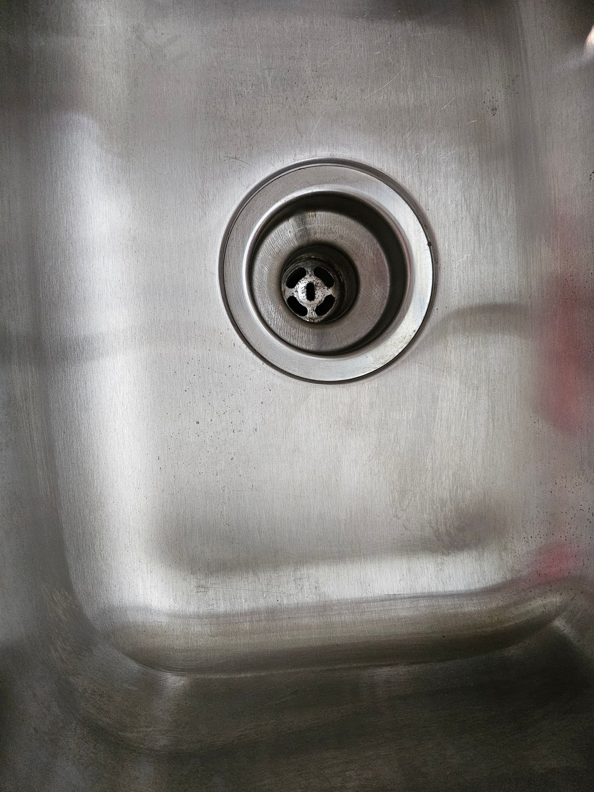 A close up of a drain hole in a sink