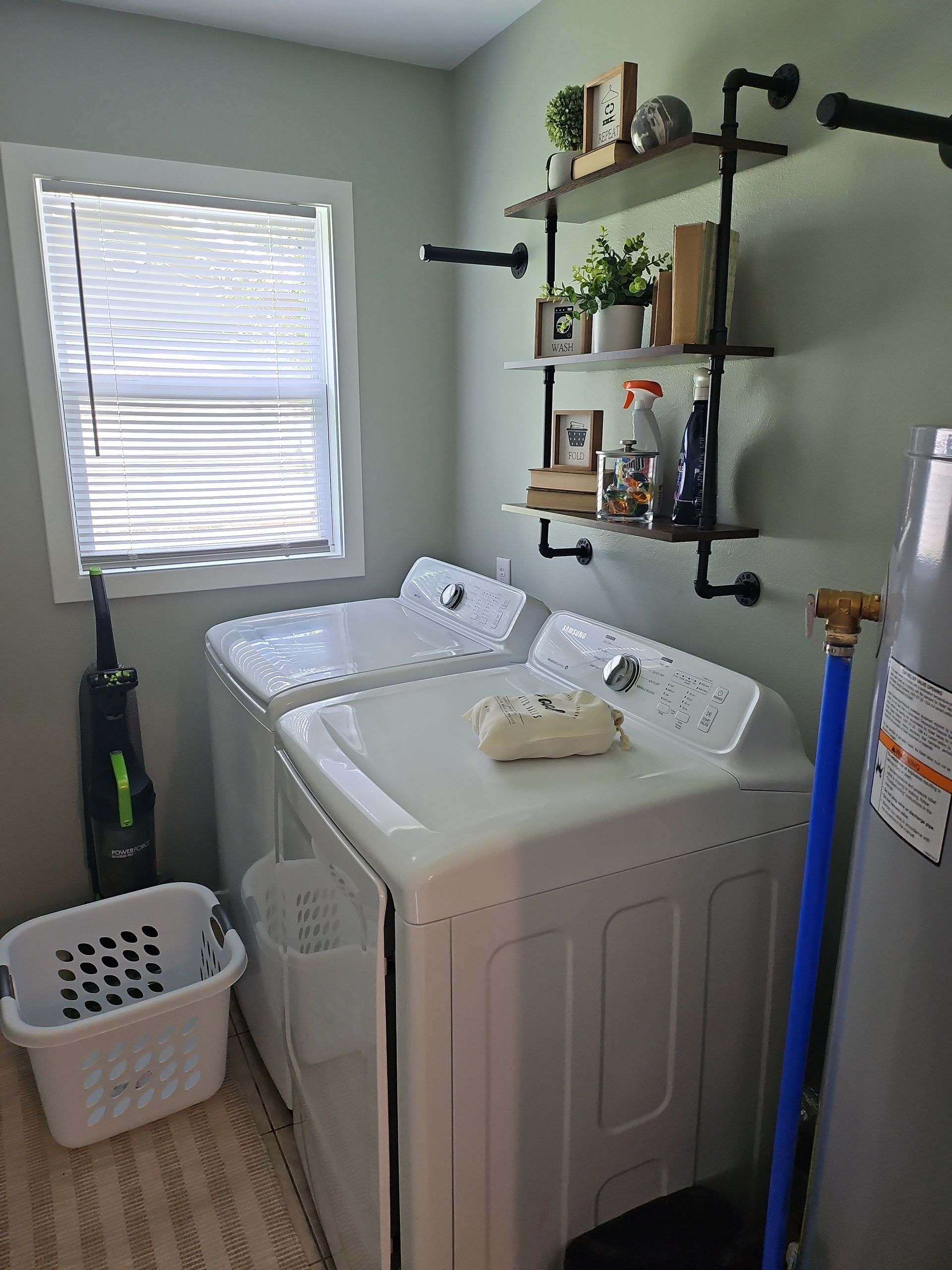 A laundry room with a washer and dryer and a basket.