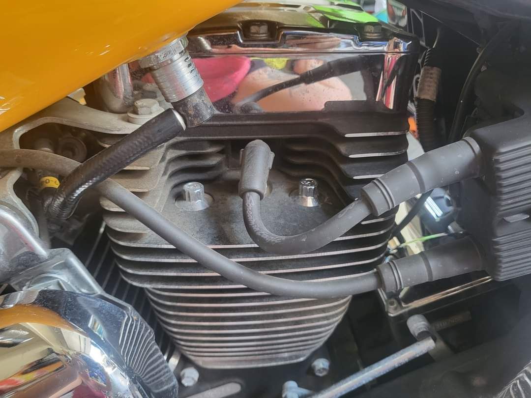 A close up of a motorcycle engine with wires coming out of it