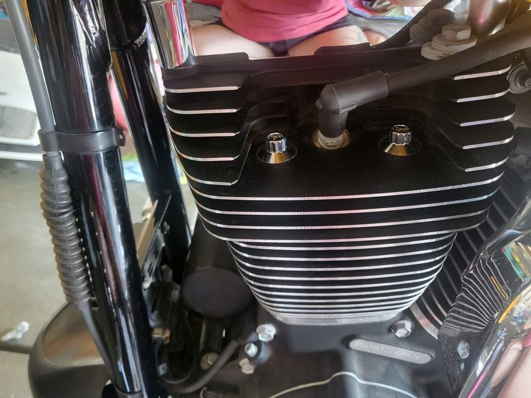 A child is sitting on the engine of a motorcycle