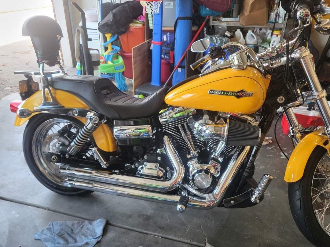 A yellow harley davidson motorcycle is parked in a garage