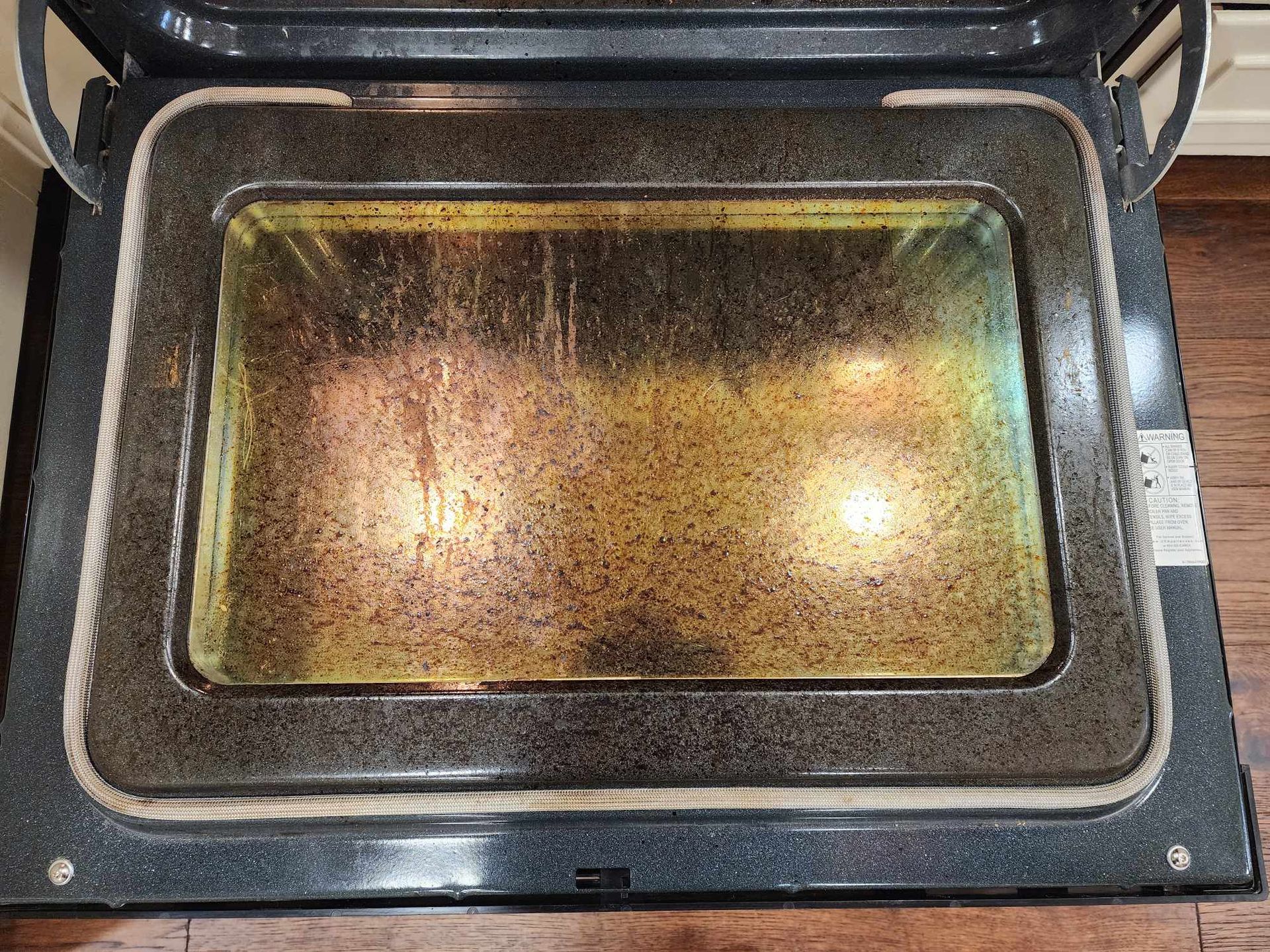The inside of a dirty oven with the door open.