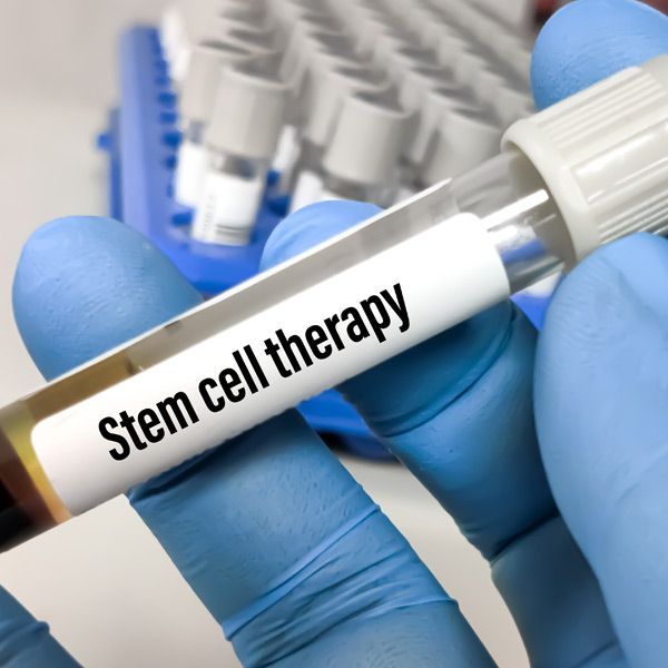 Gloved hand holding a test tube labeled 