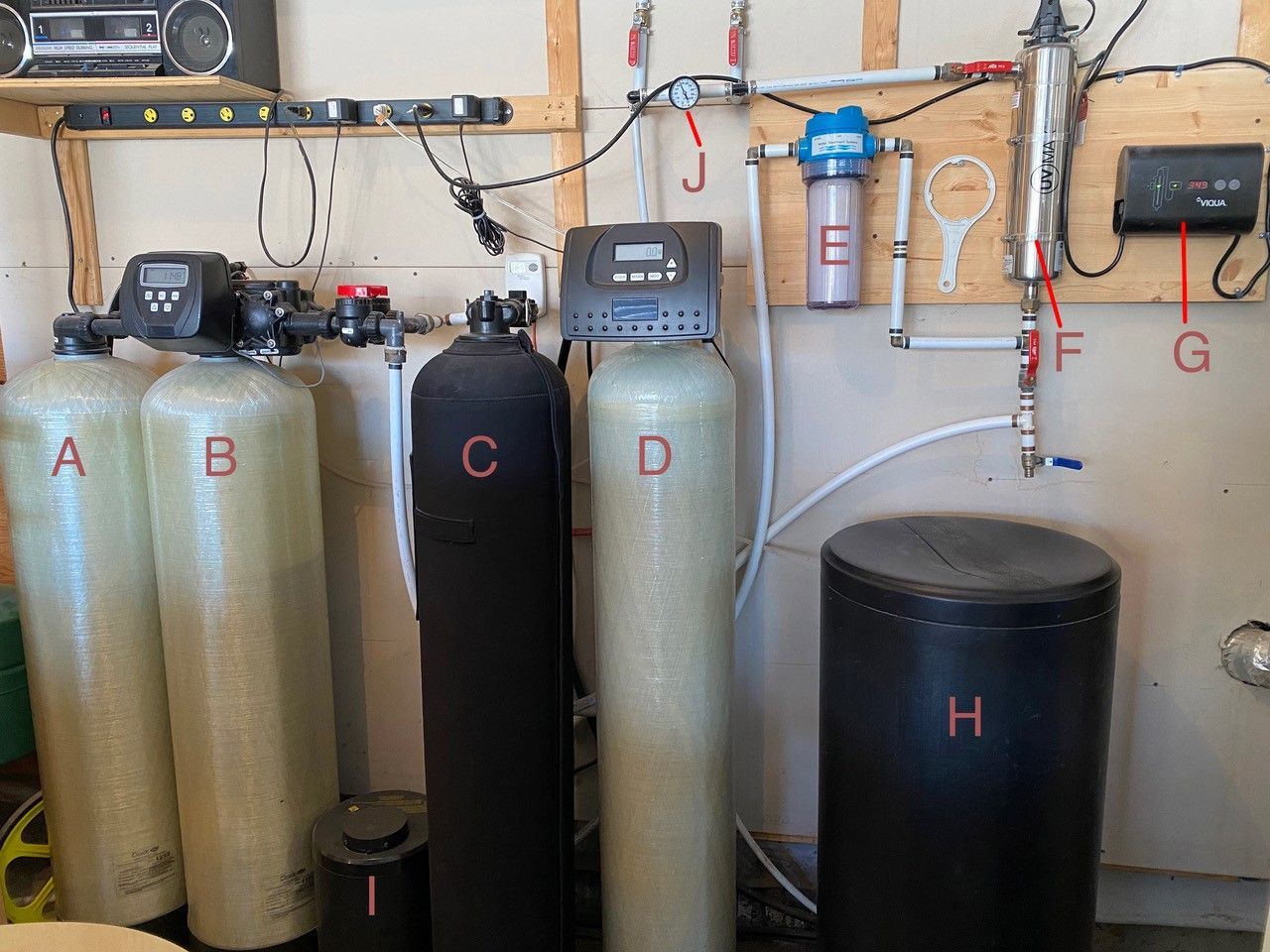 Système de filtration d'eau avec plusieurs réservoirs et composants, installé dans un garage.