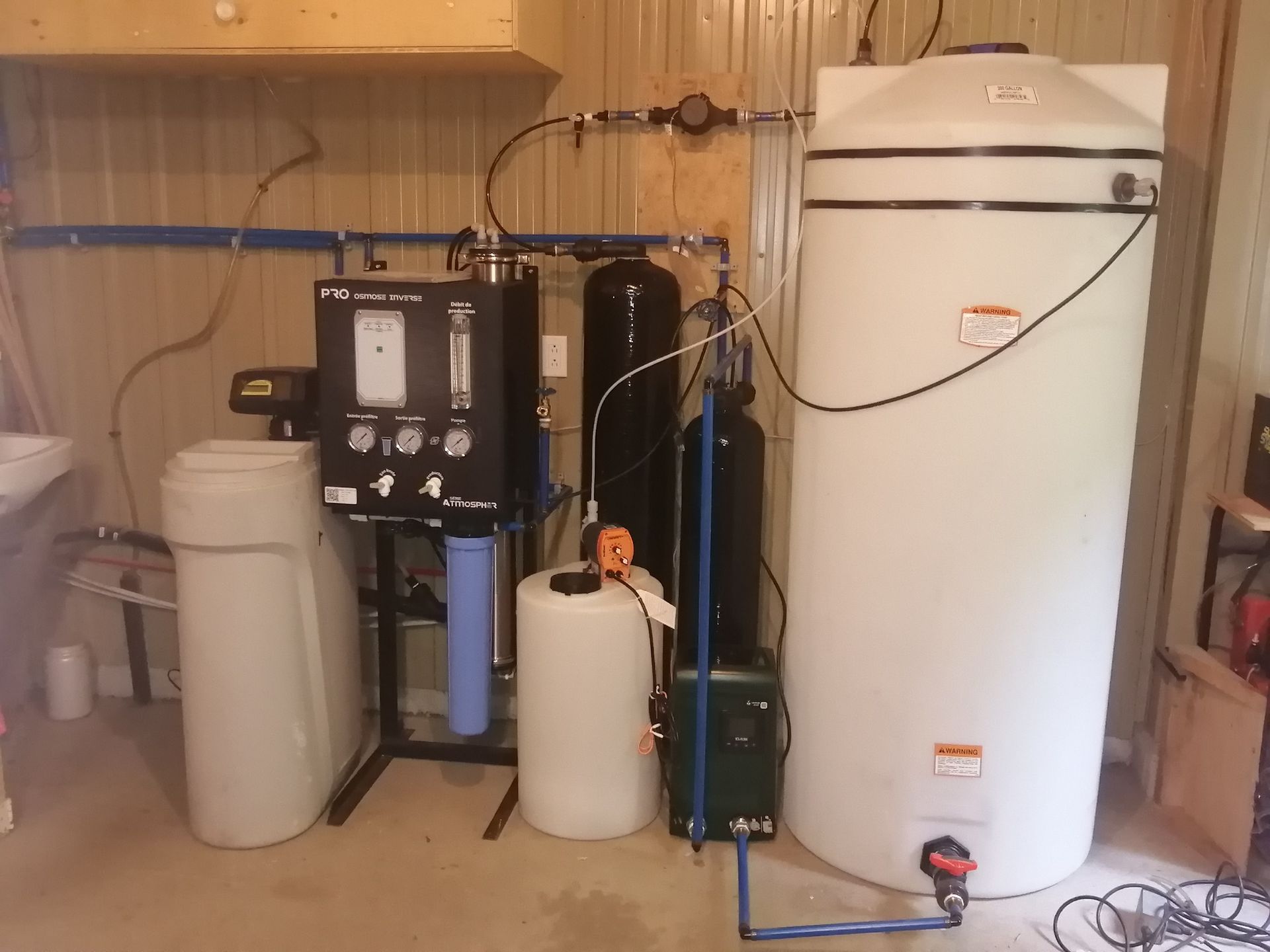 Système de filtration d'eau avec réservoirs, filtres et manomètres, installé en intérieur.