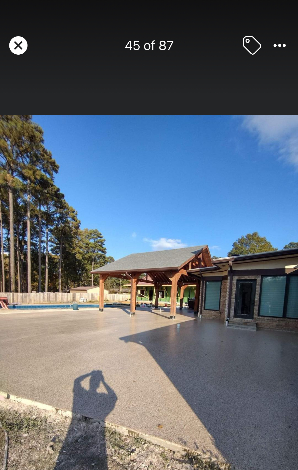 Open courtyard with gazebo, blue sky, trees, and buildings casting long shadows
