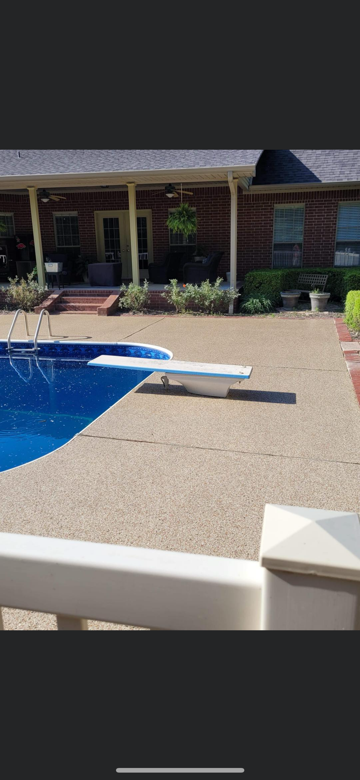 Backyard pool with blue water, white lounge chair, and house patio in the background
