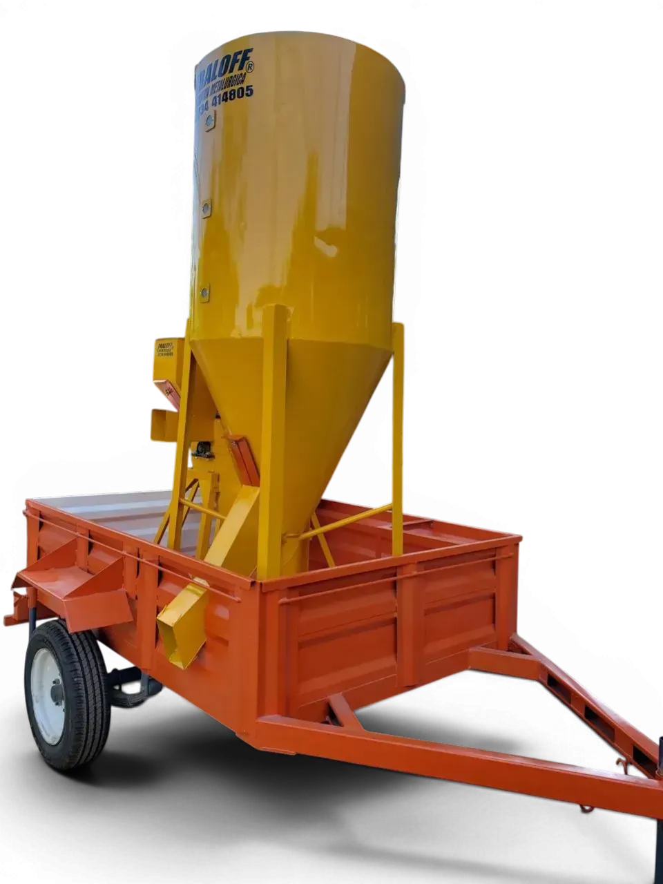 Tolva industrial amarilla montada sobre un remolque naranja con ruedas y barra de remolque.