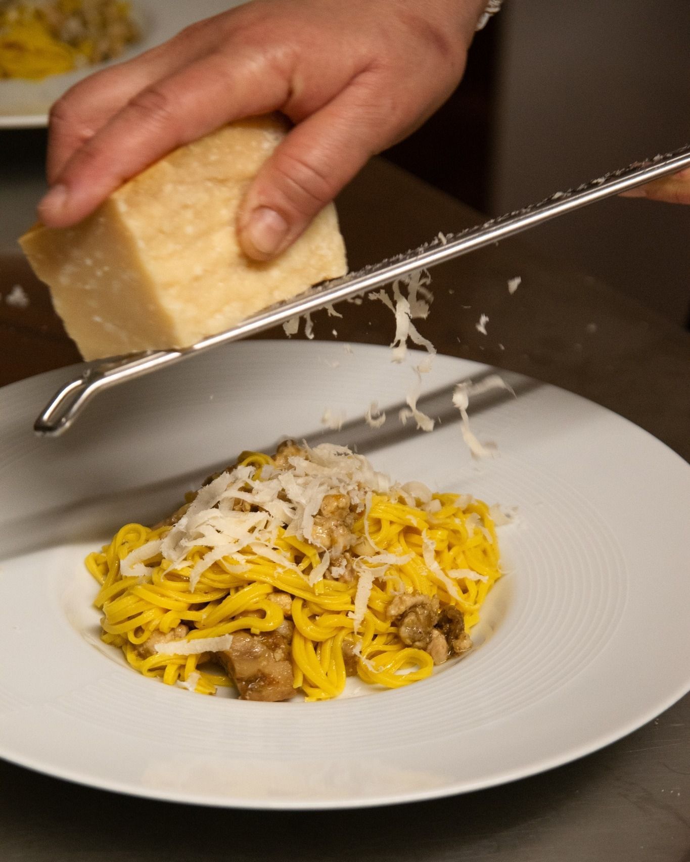 Un piatto di pasta con carne e formaggio su un tavolo.