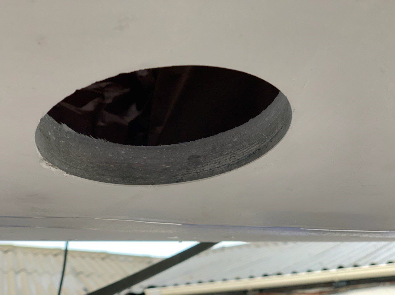 The Water inlet bore hole of a Jet Thruster water inlet is visible in the hull of a sailing yacht. The thickness of the fiberglass hull is visible