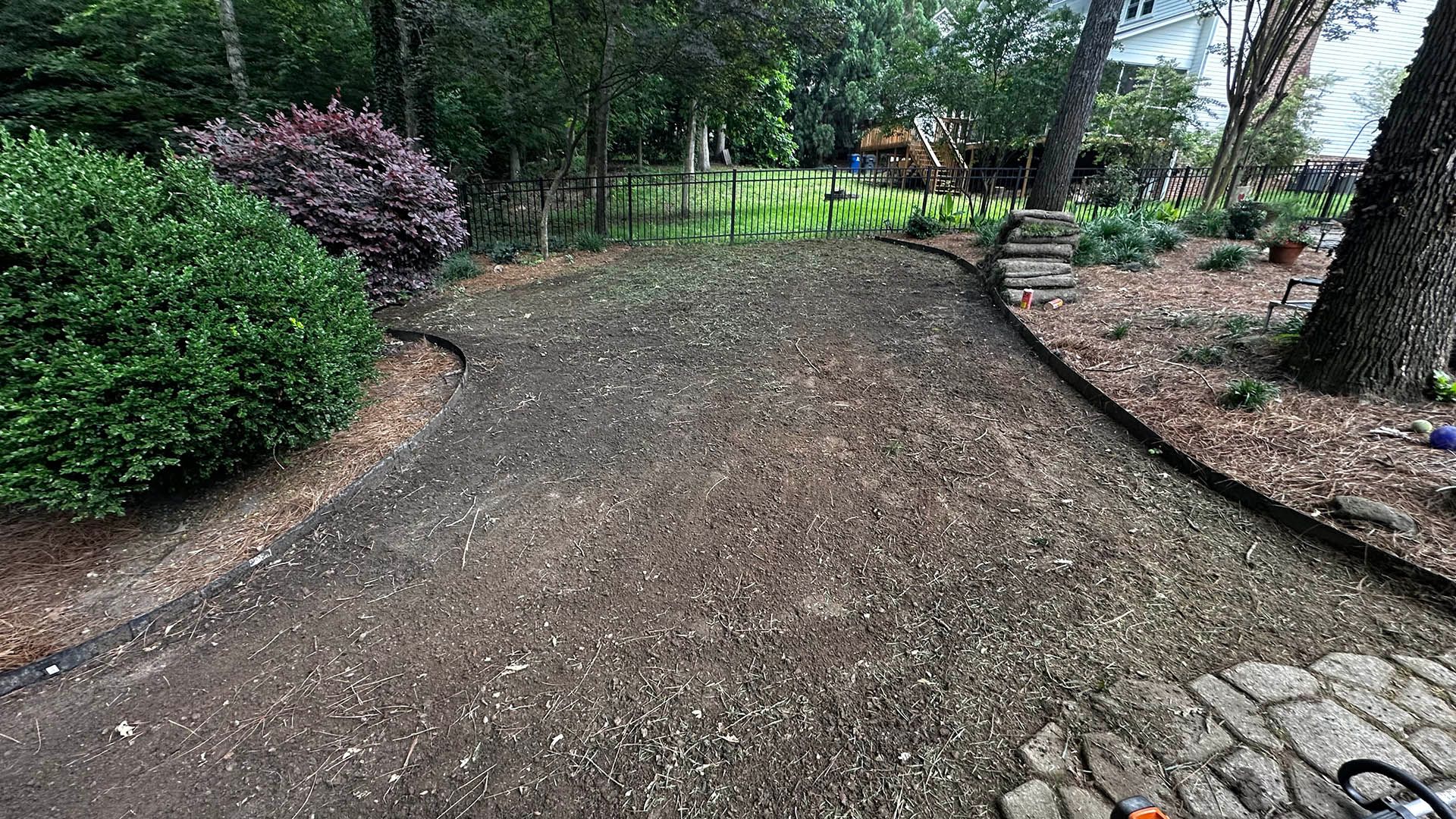 Gravel garden path bordered by shrubs and trees in a landscaped yard